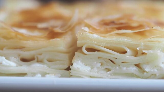 Freshly baked homemade savory pastry with cheese filling called burek, traditional balkan cuisine delicious snack food or meal close up shot