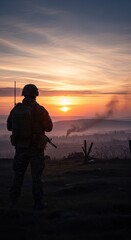 Fototapeta premium Soldier Silhouette at Sunrise with Smoke and Horizon in Background