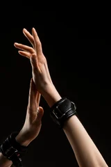 Bound hands reach up on a dark background © Wisky