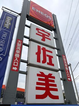 ENEOS gas station pylon sign with Usami and KeePer PRO SHOP branding and car wash entrance information in Koto city - Tokyo, Japan, March 19, 2026