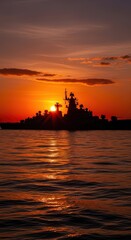 Naklejka premium Battleship Silhouette Against Vibrant Sunset Over Calm Water