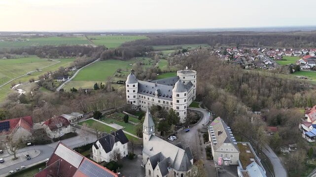Drone circles the full complex from a distant elevated perspective including the church and hilltop grounds.