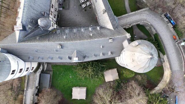 Drone looks straight down from above showing roofs towers inner courtyard and defensive walls in detail.