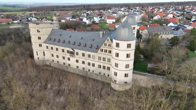 Drone presents the entire castle from the side with a clear overview of roofs towers and layout.