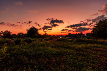 Fototapeta premium A natural backdrop of twilight sky and beautiful changing sunsets during a trip to Thailand, featuring mountains, rice fields, and temporary huts.