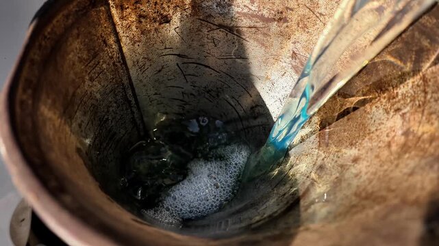 Pouring fuel into a car through the neck using a canister close-up
