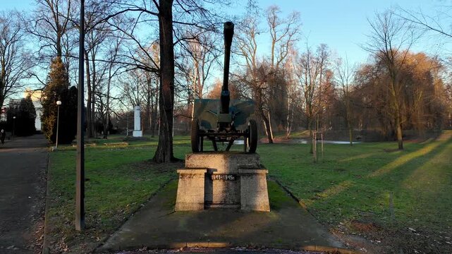 Soviet ZiS-3 divisional gun memorial on concrete pedestal 1941-1945 in a public park, historic World War II artillery monument during golden hour with autumn trees