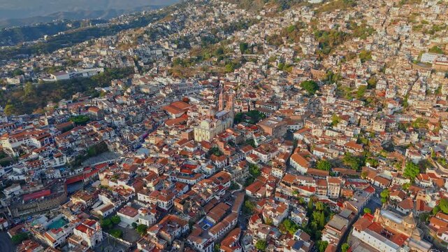 Aerial view of the city of Taxco with colonial architecture featuring tiled roofs and buildings nestled between mountain slopes, Guerrero, Mexico