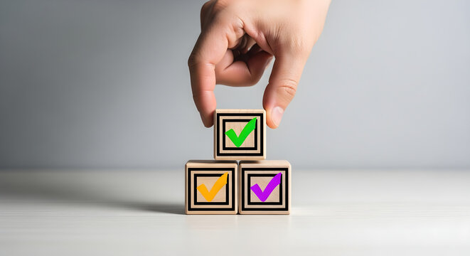 Hand building a block tower with colorful checkmarks