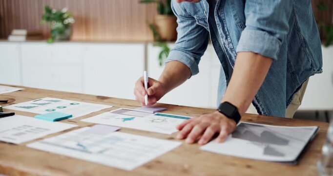 Businessman, hands and writing with sticky note or documents for analytics or statistics in office. Man, employee or analyst taking notes on papers, graph or chart for performance review in workplace