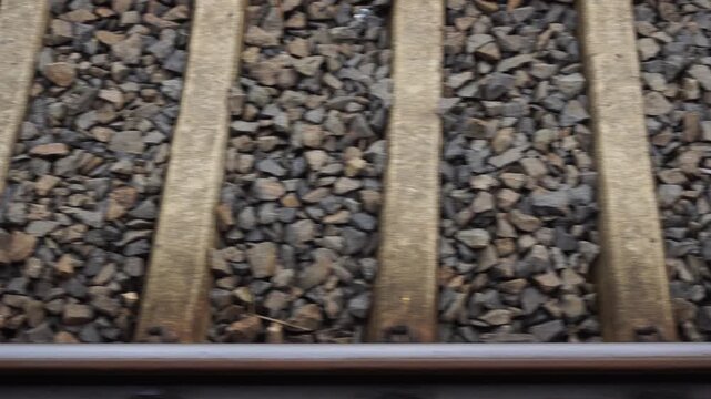 Low angle side view of railway tracks moving quickly from train window