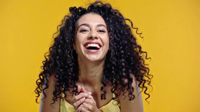 Woman laughing on yellow background.