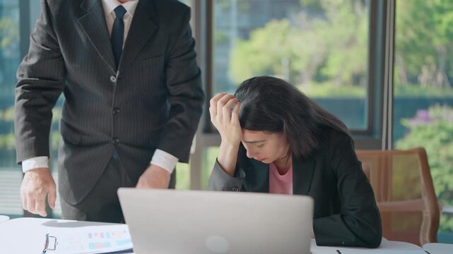 Office Despair: A scene of office distress with a dejected worker, head in hands, while a stern figure looms, creating a visual of corporate frustration and pressure.