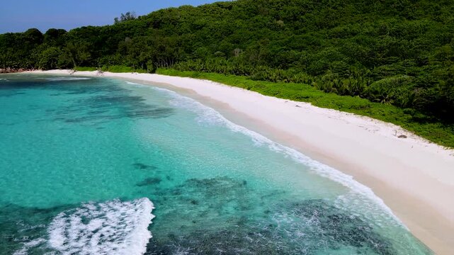 Discover the serene charm of Anse Cocos beach, clear turquoise waters meet soft white sands. Enjoy lush green surroundings and gentle waves, creating a perfect tropical escape. La Digue, Seychelles