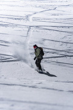 Snowboarder riding through fresh powder snow