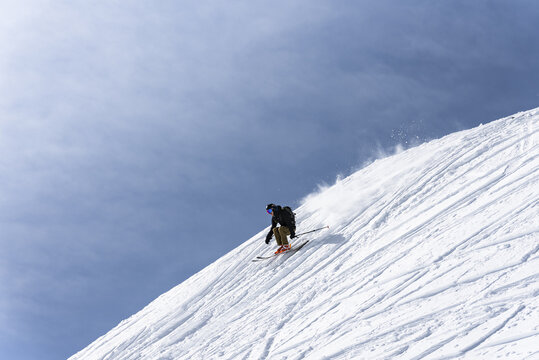Skier jumping over a natural feature in the snow