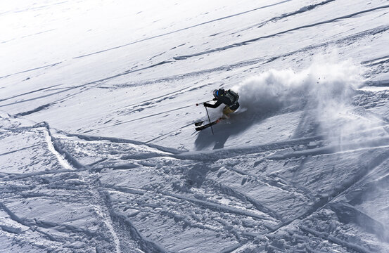 Skier carving a turn and spraying powder snow
