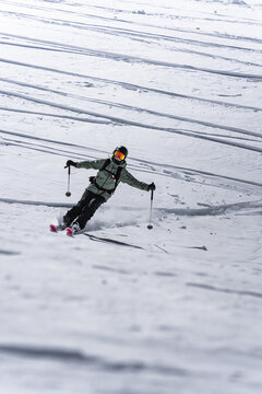Freeride skier speeding down a wide, open slope
