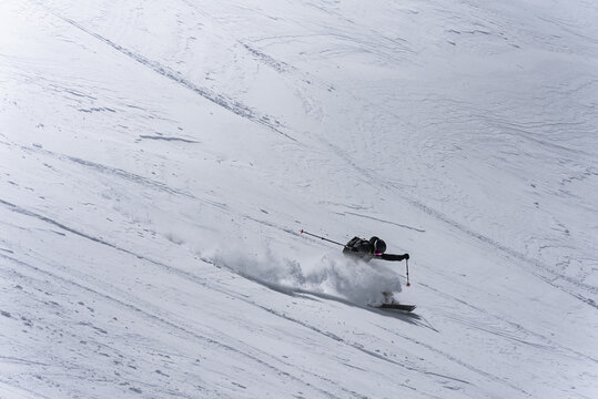 Freeride skier creating a large spray of snow