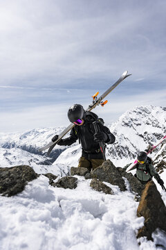 Two skiers on a snowy mountain ridge against the sky