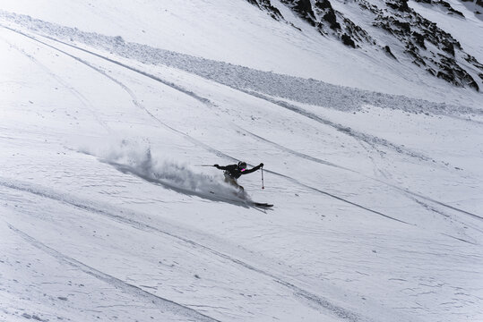 Freeride skier creating a large spray of snow