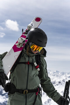 Portrait of female skier with skis on her sholder