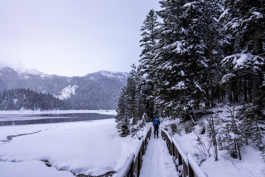 Snowy path along a frozen lake with a mountain backdrop