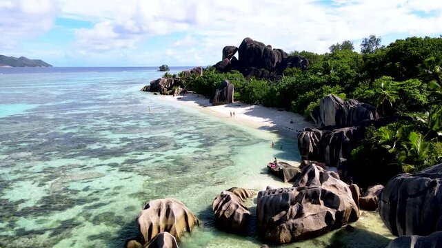 Explore the stunning shoreline of Anse Source d'Argent, where crystal-clear waters meet unique granite boulders. La Digue, Seychelles.