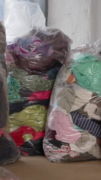 Large bales of second-hand kids clothing and footwear for wholesale resale or export. Concept of thrift business and circular fashion market