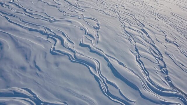 Snow-covered landscape with flowing patterns and textures, showcasing the gradual changes in surface contours under natural light across three frames