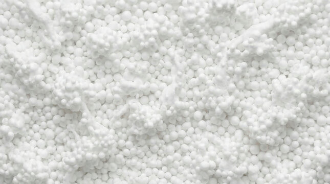 Flat lay of microscopic white polystyrene foam beads, dry squeaky snow-like texture background.