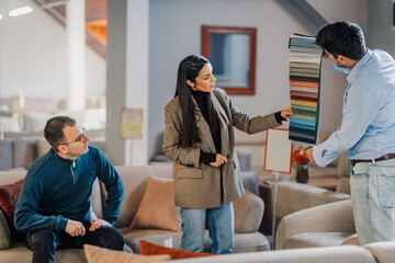 Obraz premium Couple choosing fabric swatches for new sofa