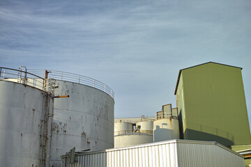 Fototapeta premium Silo, sky and architecture for agriculture, low angle and property development for business. Outdoor, empty and real estate for farming buildings, storage and industry for factory and warehouse