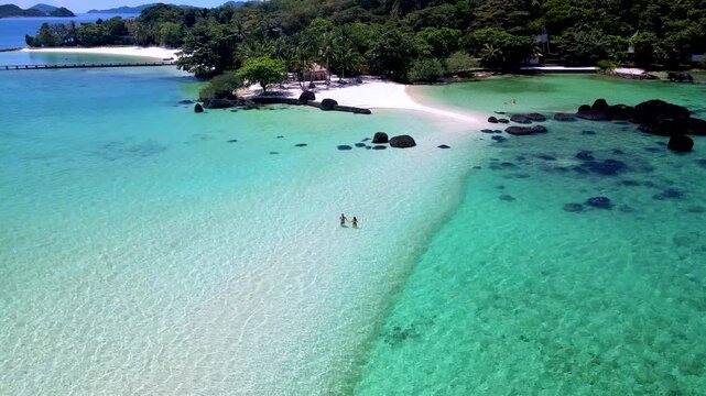 Immerse yourself in the stunning beauty of Koh Kham in Trat, Thailand. A couple walking on a sandbank 