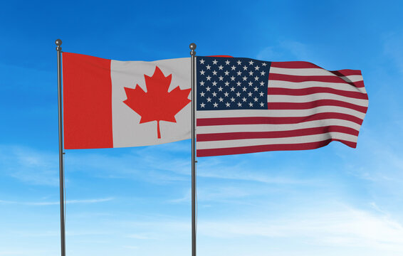 Canada and USA Flags Flying Side by Side - Canadian and American National Banners Against Blue Sky