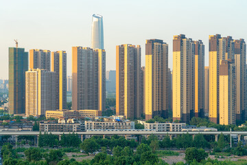 Fototapeta premium High-Speed Train Passes Through Urban Neighborhood with Modern Tower Developments