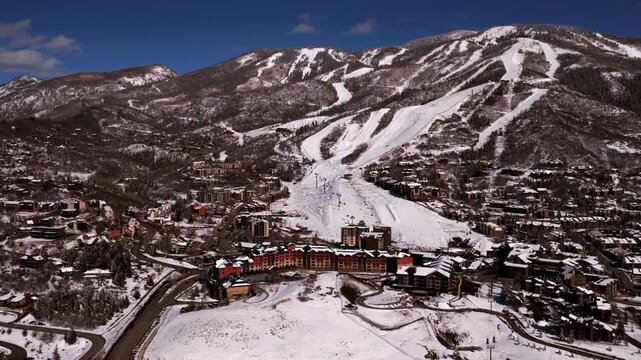Steamboat Ski Resort Spring Winter morning sunny blue sky Steamboat Springs Colorado aerial drone fresh snow groomed ski trails Olympic training lodging Gondola chairlift Sunshine Peak forward motion