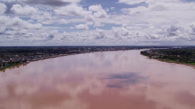 Very high altitude flying slow forward moving wide angle view of the Mekong River during dry season with Laos and Thailand on the opposite sides.