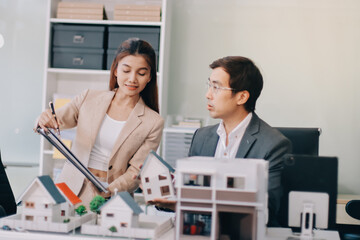 Fototapeta premium Real Estate Broker discussing with a customer model install solar roof house modern project in the office, real estate developer alternative energy, development business sustainable, zero energy, ESG.