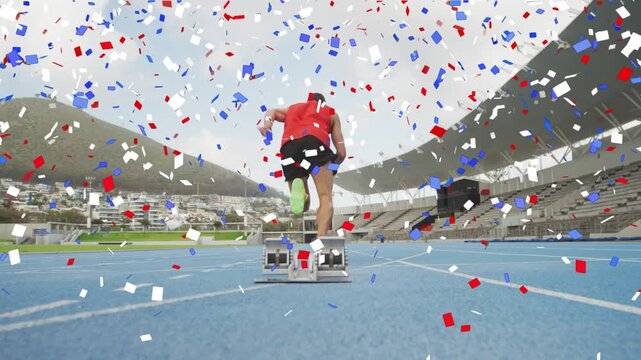 Male sprinter pushing off blocks and launching down track, confetti falling around him for training