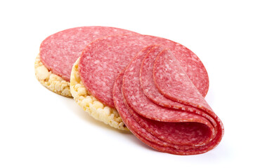 Obraz premium Salami slices on rice cakes, isolated on white background