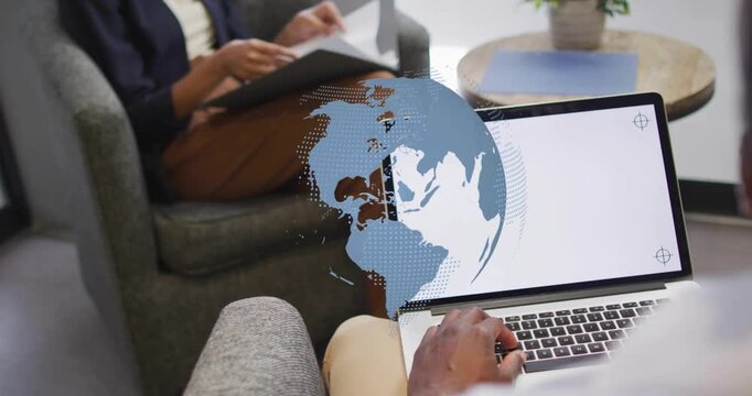 Animated globe appearing on laptop, causing man typing and woman flipping folder for business use