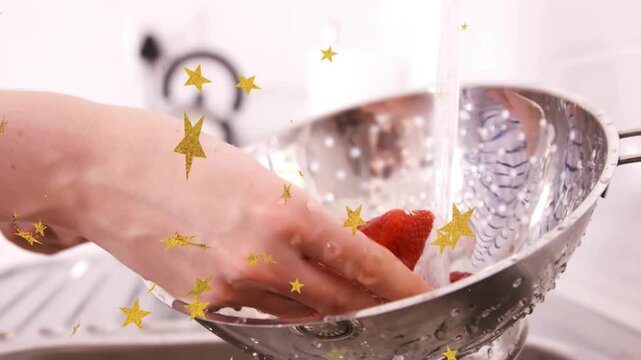 Hands rinsing strawberries under tap for food prep colander filling gold stars overlay