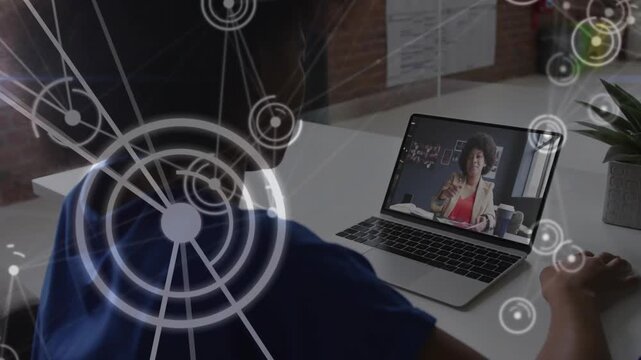 Student leaning over laptop following teacher gesturing, using mouse for lesson with HUD on left