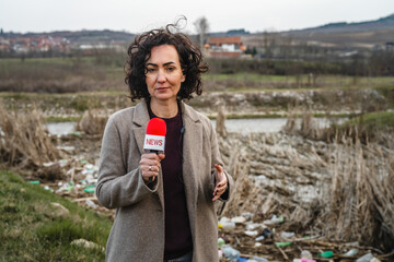 Fototapeta premium Journalist reporting environmental pollution in a polluted wasteland
