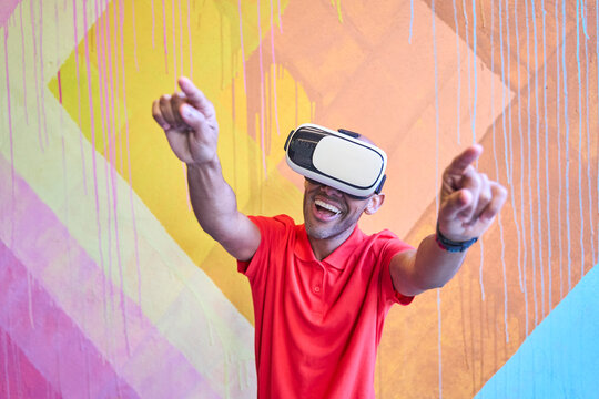 Smiling man experiencing virtual reality with VR headset playfully