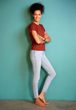 Portrait of a smiling woman standing barefoot in casual clothing