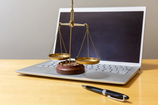 PCとキーボードの上に置かれた天秤　裁判 ネット犯罪 サイバー犯罪 裁判IT化のイメージ 
