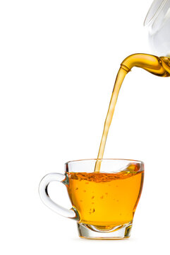 Glass cup of tea with teapot filling, isolated on white background.