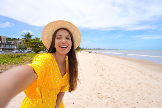Self portrait of cheerful young woman on Cabo Branco beach, Joao Pessoa, Brazil